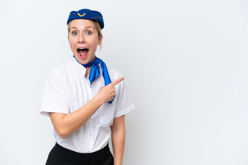 Airplane blonde stewardess woman isolated on white background surprised and pointing side