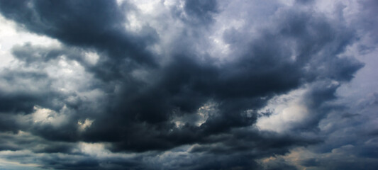 The dark sky with heavy clouds converging and a violent storm before the rain.Bad or moody weather sky and environment. carbon dioxide emissions, greenhouse effect, global warming, climate change.