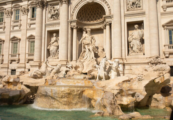 Fototapeta na wymiar Trevi Fountain in Rome, Italy. Ancient fountain. Roman statues at piazza in old medieval city among traditional italian houses and street lamps. Famous landmark.