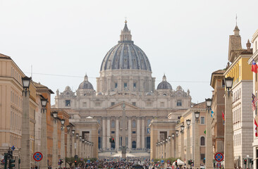 Obraz premium Tourists on the St. Peter's Square, architectural masterpiece with Michelangelo's dome in Vatican City, Rome. Famous Italian landmark.