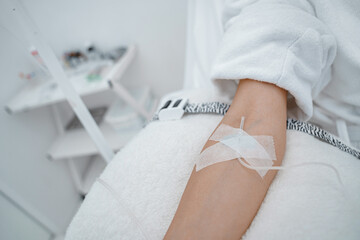 Close up of woman in white bathrobe during medical procedure in beauty clinic