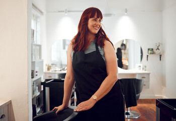 Salon, small business and happy hairdresser preparing or getting ready for work at her station. Happiness, smile and proud hairstylist or beautician with beauty hair care startup company in Australia © K Abrahams/peopleimages.com