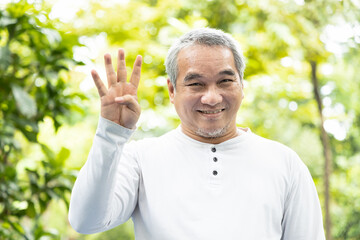 Confident happy smiling old asian man pointing up 4 fingers