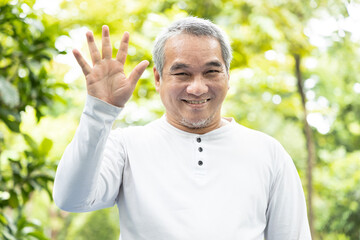 Confident happy smiling old asian man pointing up 5 fingers - obrazy, fototapety, plakaty