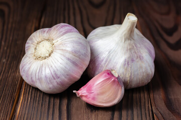 Garlic cloves on wooden table. Fresh peeled garlics and bulbs.