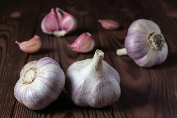 Garlic cloves on wooden table. Fresh peeled garlics and bulbs.