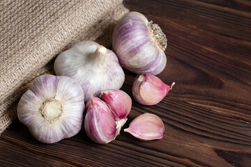 Garlic bulb on wooden background and sackcloth. Close up