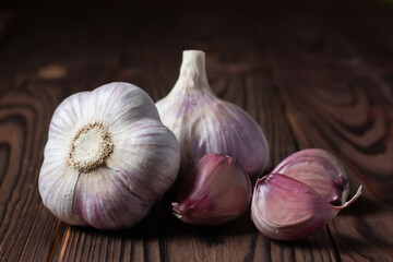 Garlic cloves and bulb on wooden table. Fresh peeled garlics and bulbs.