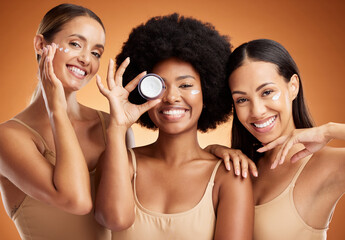 Beauty, skincare and portrait of women with smile in studio with face cream or moisturizer. Happiness, diversity and friends with facial routine for cosmetics, health and wellness by brown background - obrazy, fototapety, plakaty