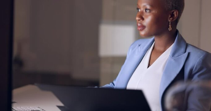 Night, computer and black woman reading information from a folder while working in a dark office at night. Corporate and African worker typing on pc while doing a deadline for a proposal in overtime
