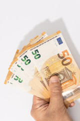 Hand holding a group of 50 euro banknotes on white background. Copy space