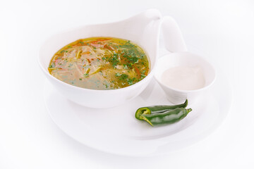 Chicken soup or broth with noodles, herbs and hot green pepper