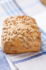 Gold rustic crusty loaves of bread and buns on wooden background. Still life captured from above top view, flat lay.