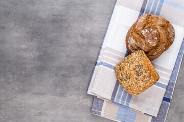 Gold rustic crusty loaves of bread and buns on wooden background. Still life captured from above top view, flat lay.