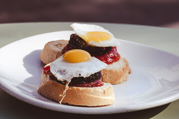 Typical spanish tapas with fried egg, chorizo and fried pepper.