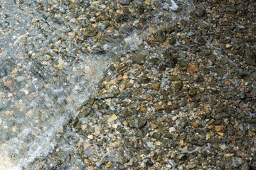 The rocks are under shallow water, so clear that you can see through them.