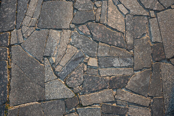 Obraz premium The surface of the pavement laid with granite slabs. Stone surface illuminated by sunlight