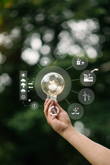 Hand holding anti nature light bulb on green leaf with renewable and sustainable development energy source icon. for renewable,love the world