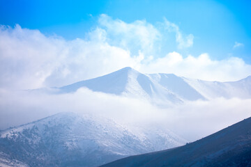 Beautiful nature of rocky mountains and peaks with glaciers. Unusual landscape of nature. Rocks on the background of the sky with clouds. Bad weather cyclone, rainy season, foggy day.