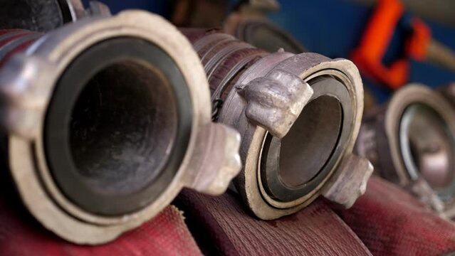 Rolled fire hoses arranged in rows, in a fire truck or fire cabinet. Fire station equipment.