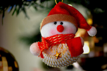 Close-up of snowman hanging on the Christmas tree during Christmas. Space for text.