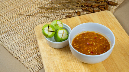Top view of Thai shrimp paste chili dip eat with fresh eggplant on wooden board, Thai food, Thai chili paste, Nam Prik, Copy space.