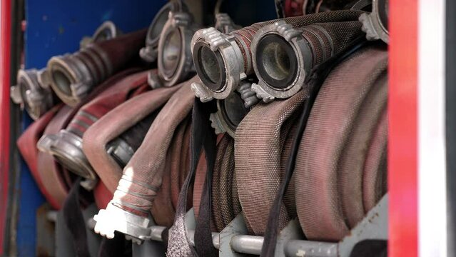 Rolled fire hoses arranged in rows, in a fire truck or fire cabinet. Fire station equipment.