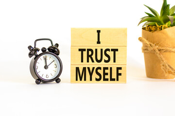I trust myself symbol. Concept words I trust myself on wooden blocks. Black alarm clock. Beautiful...