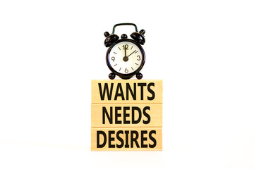 Wants needs and desires symbol. Concept words Wants Needs Desires on wooden blocks. Black alarm clock. Beautiful white background. Business, psychological wants needs and desires concept. Copy space.