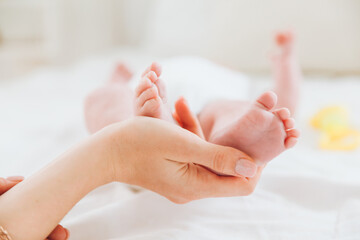 the mother's hand holds the baby's legs. mother and child