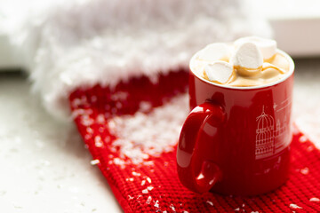 Red Marshmallow Coffee Cup Covered with White Snow on a Gift Sock