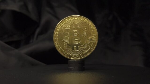 Real Bitcoin closeup rotate video. Burning golden crypto currency bitcoin in fire slow motion
