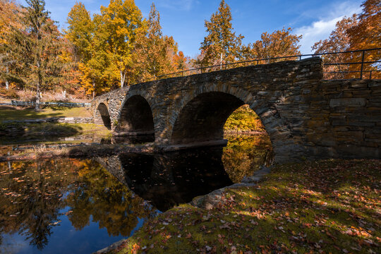Stone Arch Bridge in Callicoon, NY, Catskill Mountains, surrounded by brilliant fall foliage on a bright autumn morning