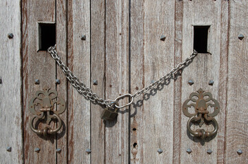 Vieilles portes en bois fermées par une chaine et un cadenas 