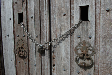 Vieilles portes en bois fermées par une chaine et un cadenas 