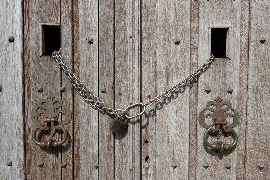 Vieilles portes en bois ferm&eacute;es par une chaine et un cadenas 