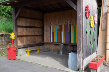 Abri de bus scolaires et autocars décoré avec un panneau de bois découpé et peint  qui représente des grands crayons de toutes les couleurs 