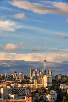 City landscape in the rays of the setting sun. The TV tower rests against the cloudy sky. © Sergii