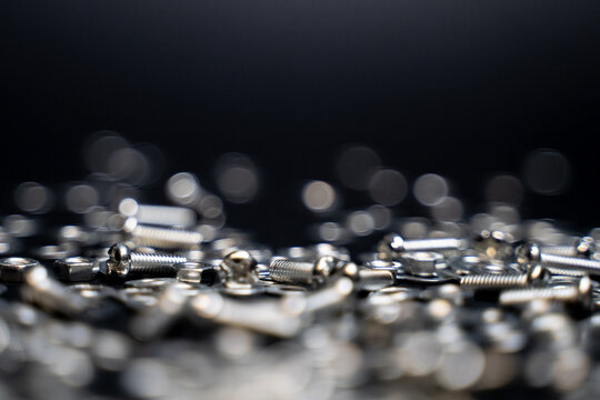 Close up crafts of bolts, screws, nuts, washers, mechanical parts falling and bouncing in slow motion. black background. precision work. Work as a carpenter. Joinery and construction work.