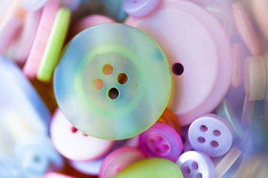 Collection of pastel buttons in jar close up