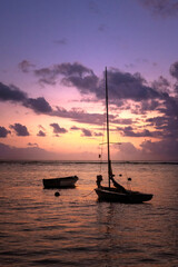 Fototapeta premium Sunset over the tropical beach with boat at La Digue , Seychelles . silhouettes of a 2 boats amazing cloudy sky on sunset at tropical Beach. 