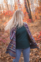 Beautiful young woman walking in the autumn forest
