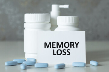 MEMORY LOSS text on a card on the table next to the jar with the medicine