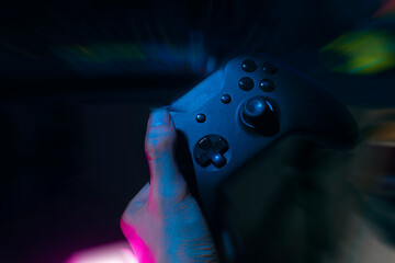 gamer playing the online game with joystick controller in neon glow dark cyberpunk room, gaming and...