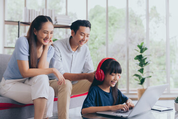 Cheerful asian parent dad and mom teaching daughter studying online and doing homework, Education concept