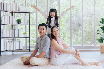 Portrait of asian family sitting on floor posing smiling happy moment of unity family love together...