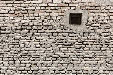 Fototapeta na wymiar Uneven surface of a brick wall, Bukhara, Uzbekistan