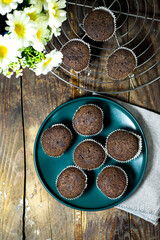 homemade chocolate muffins  with daisy flowers on wood table