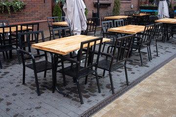 Fototapeta na wymiar Cafe table and chairs on the street KALiningrad. Wooden table with black chairs
