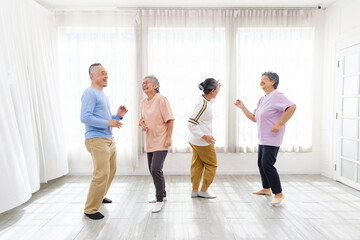 Active Asian senior group mix with man and woman exercise by dancing together at home with relaxing, smiling and laughing. Indoor activity for mature seniors and retirement people.
